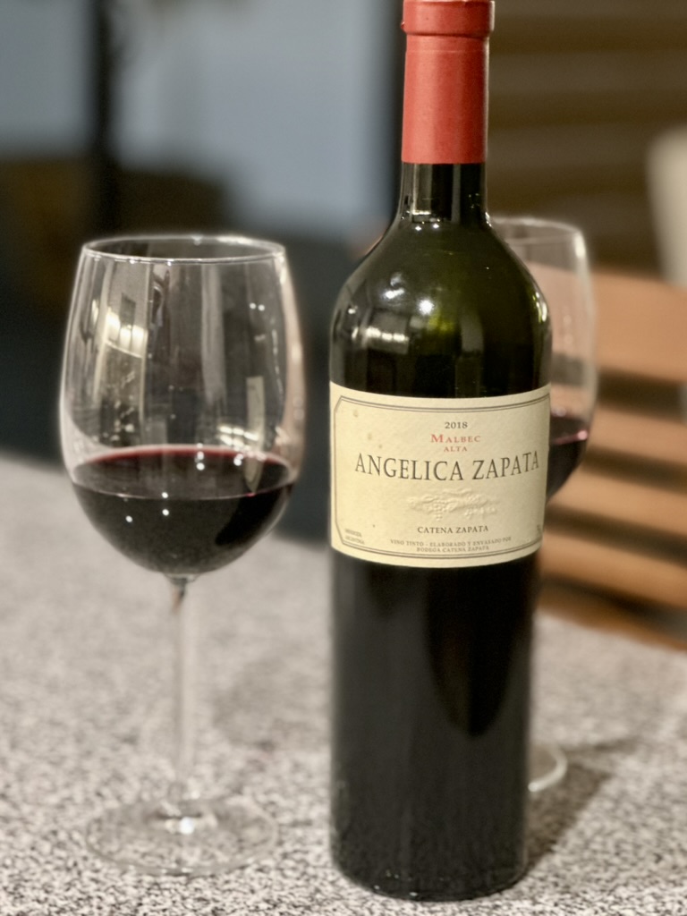 Botella de Angélica Zapata Malbec junto a una copa de vino