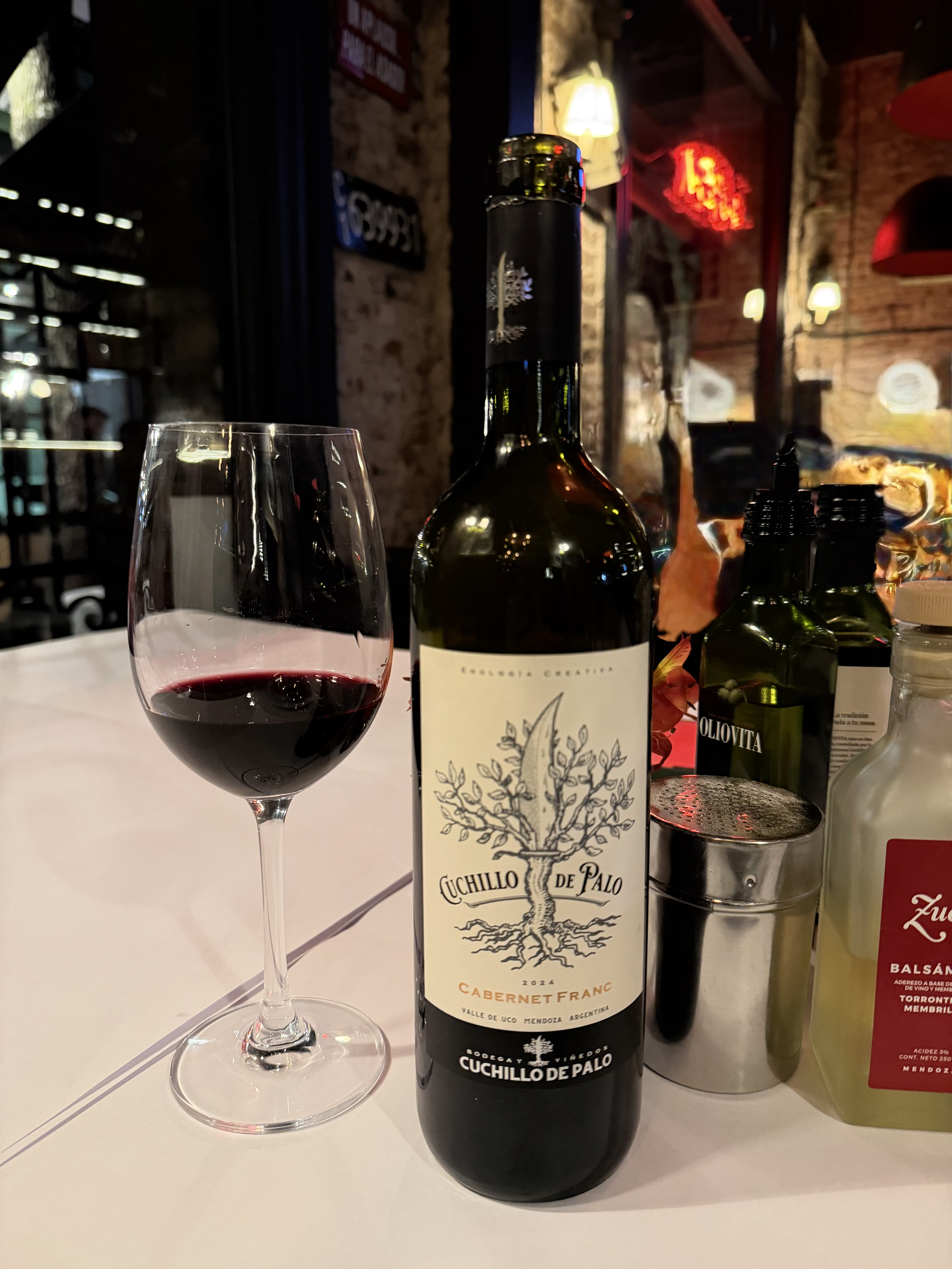 Botella de Cuchillo de Palo Cabernet Franc 2024 junto a una copa de vino tinto en La Cabrera
