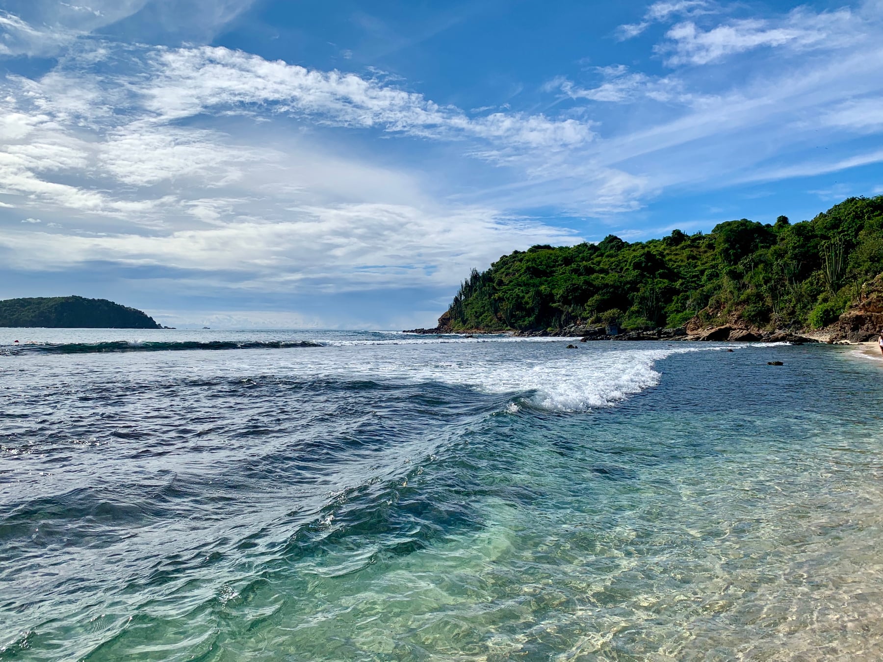 Mar transparente y pequeñas olas junto a la costa rocosa de Isla Ixtapa