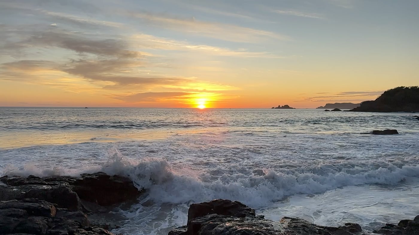 Atardecer sobre el mar y las rocas de Porto Ixtapa