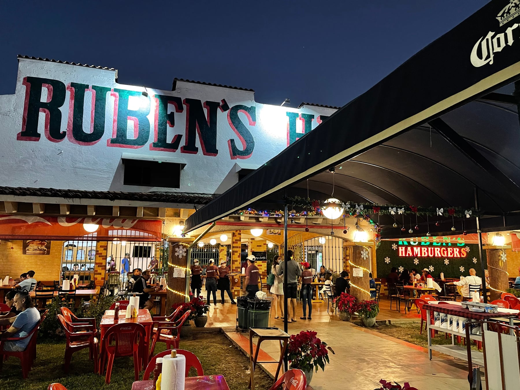 Fachada iluminada de Rubens Hamburgers en Ixtapa durante la noche