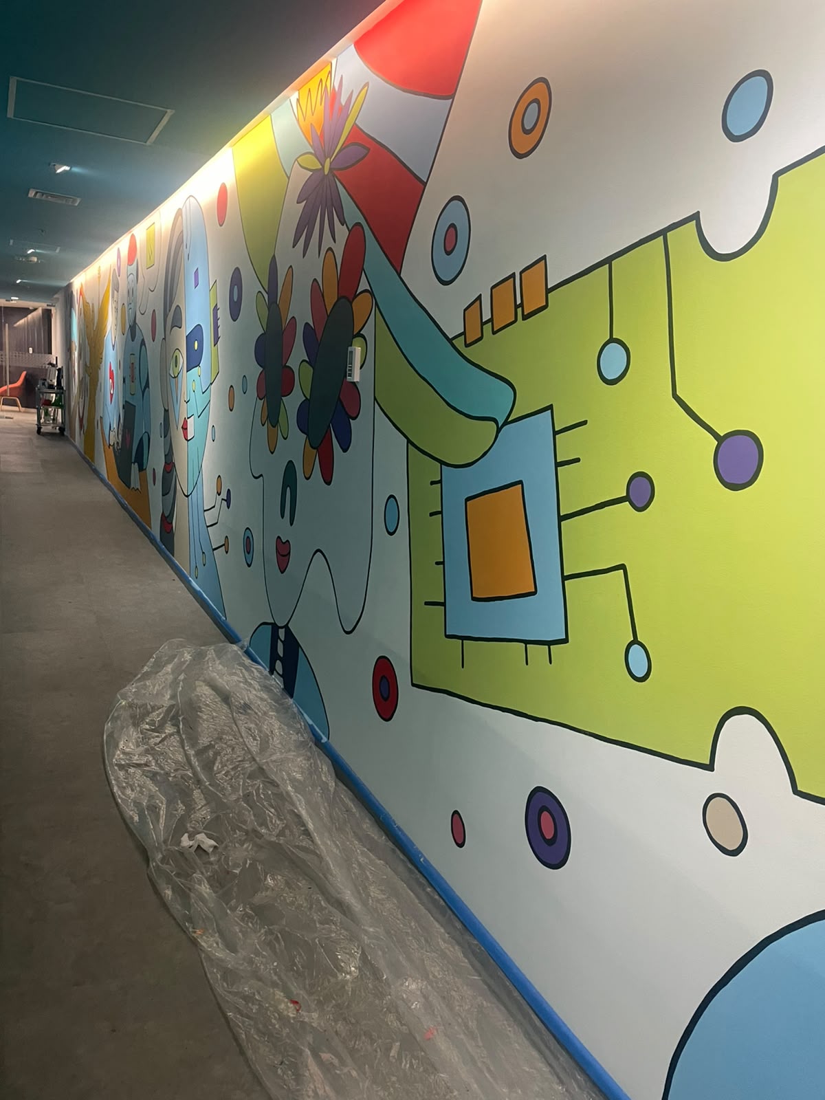 Parte tecnológica del mural en ejecución, con las primeras formas pintadas sobre la pared