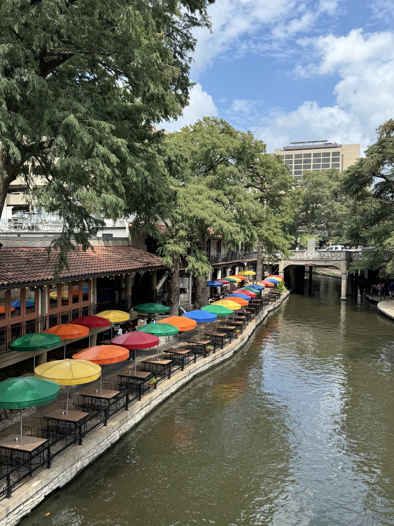 Restaurantes y sombrillas coloridas junto al River Walk