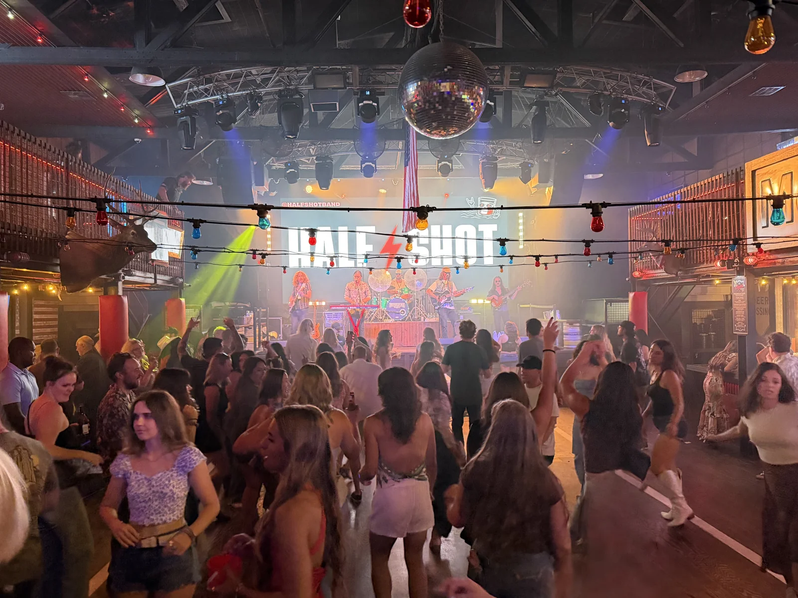 Una banda en el escenario y público frente a ella durante una noche en Moonshine Flats.