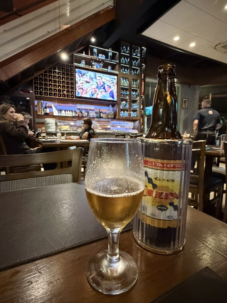 Cerveza y botella sobre una mesa en Cruzeiro's Bar